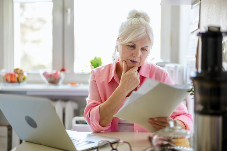 Senior woman working with laptop and documents | Alex & LaFleur, Attorneys at Law