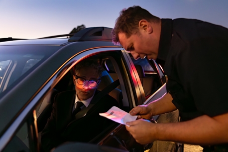 Shot of senior driver and a police officer looking at his registration.
